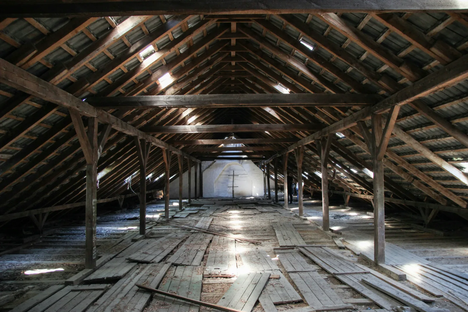Leerer Dachboden mit altem Holzdachstuhl und losen Dielen